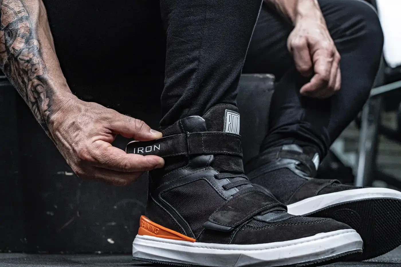 Atleta ajustando o velcro da bota Iron preta